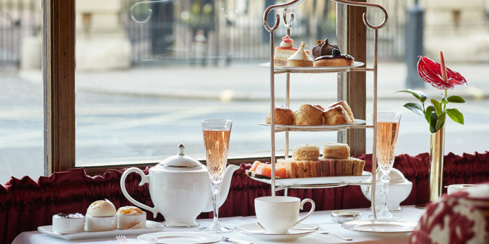 An Afternoon Tea presented on a tiered stand is on a table in front of a window