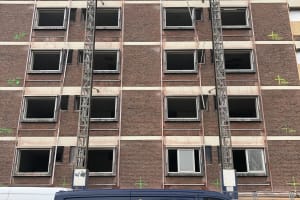 Verwijdering asbesthoudende kit uit gevels.