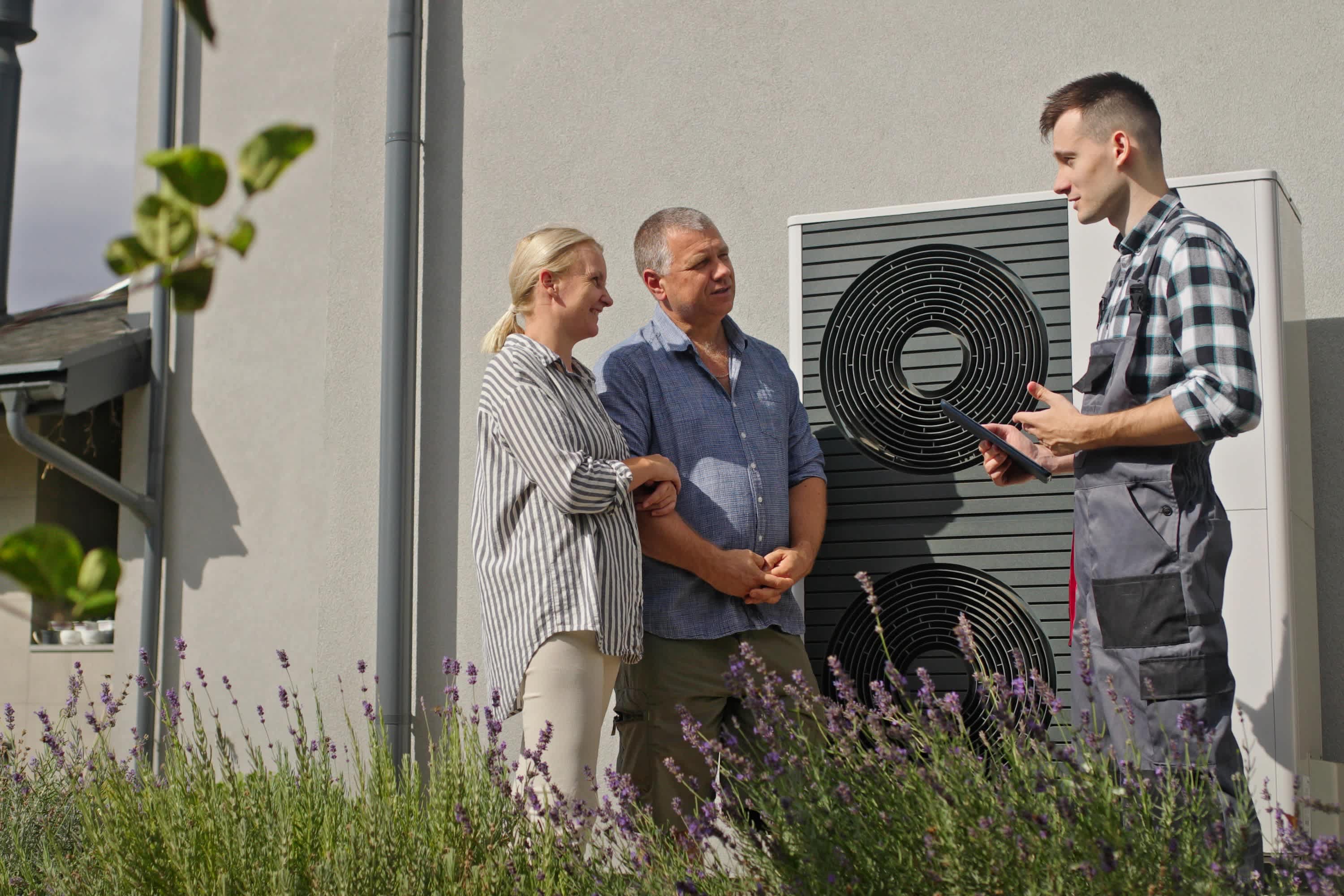 erkende installateur warmtepomp geeft uitleg naast buitenunit