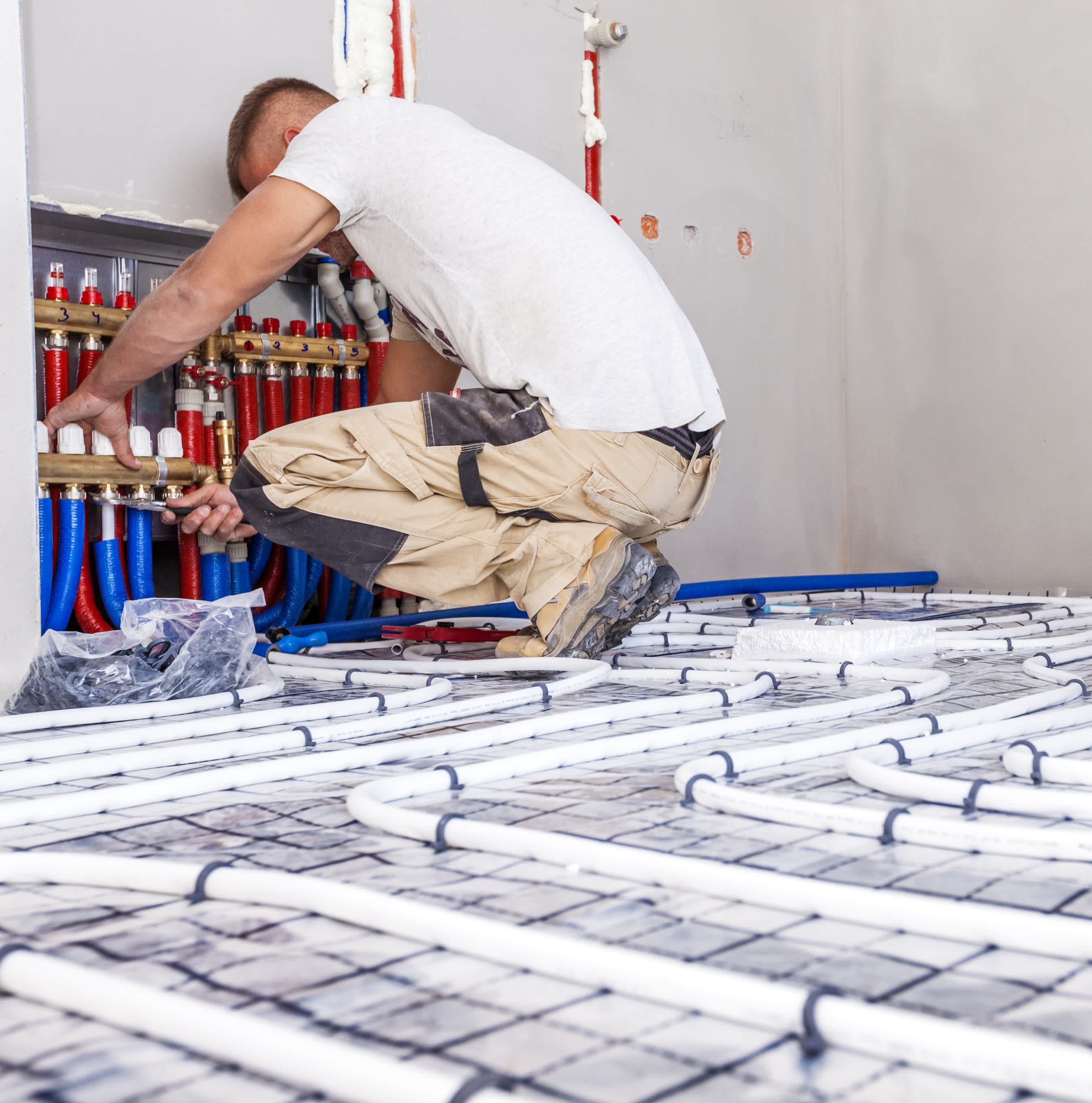 vakspecialist sluit de leidingen voor vloerverwarming aan