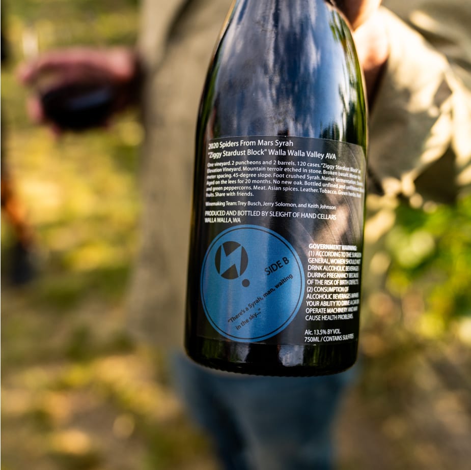 Trey Busch holding a bottle of 2022 Syrah