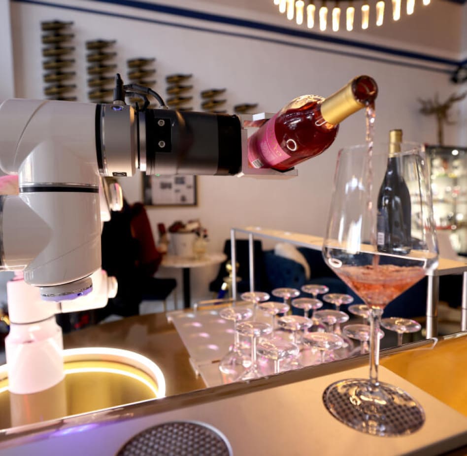 A robot named “Robinovino” pours a glass of rose at Maria Concetto Winery tasting room in Calistoga, Thursday, Dec. 14, 2023. (Beth Schlanker / The Press Democrat)