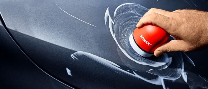 Person poliert eine Autotür