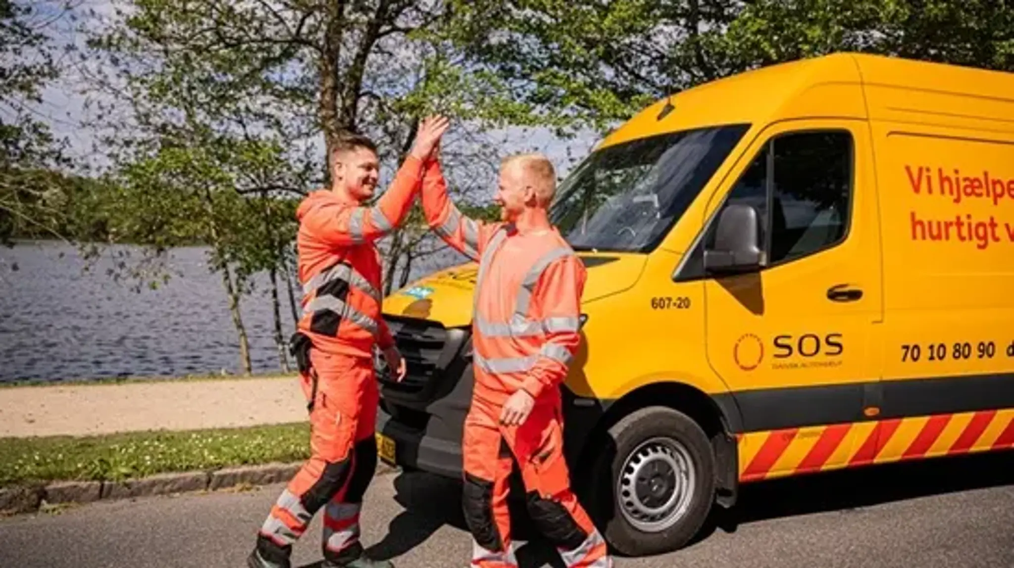 To autoredderede giver highfive foran autoredderbil