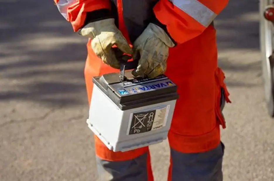 Autoredder står med bil batteri
