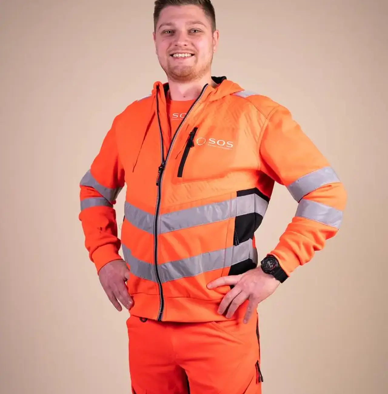 Autoredder står med armene i siden og smiler til kameraet