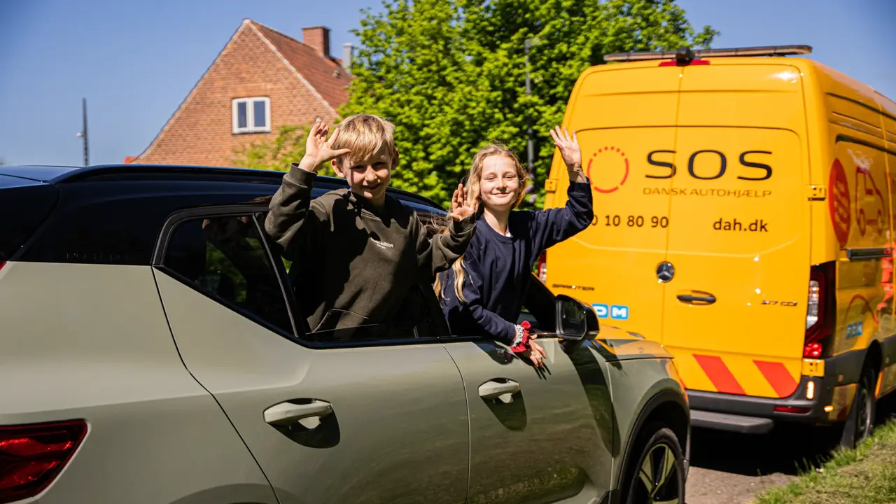 Børn vinker ud af vinduet