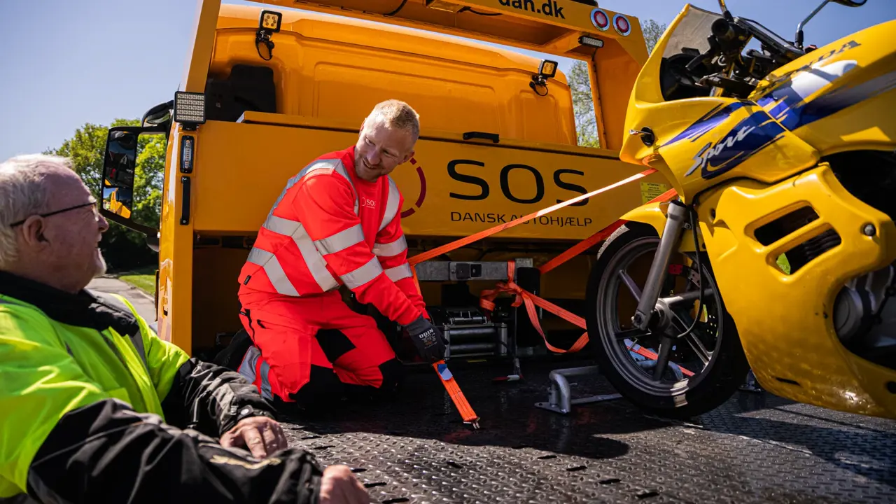 Motorcykel på lad med autoredder ved siden af