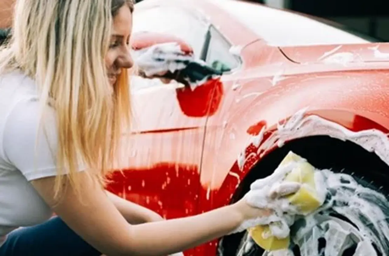 Kvinde vasker rød bil