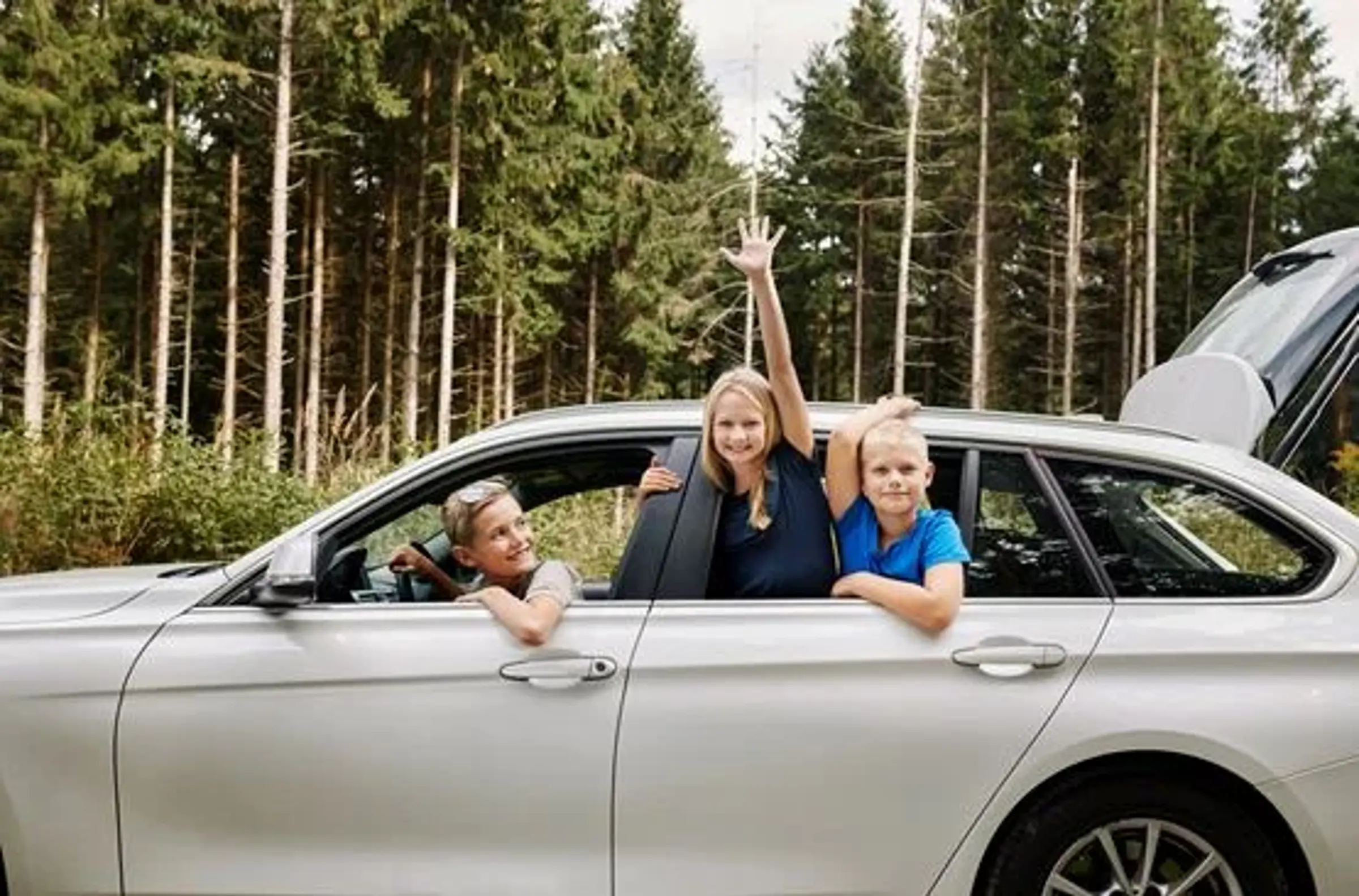 Bil set fra siden. 3 børn i bilen.