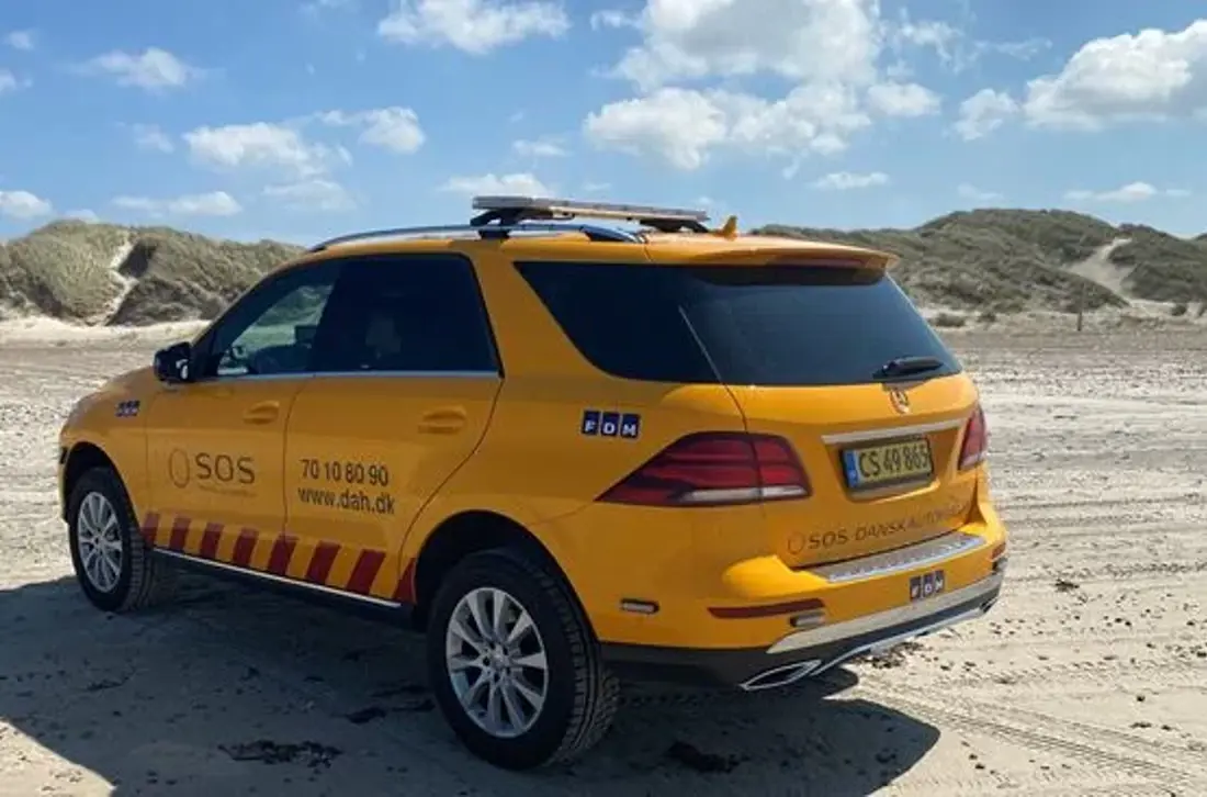 Autoredder bil på strand. Bilen er en Mercedes.