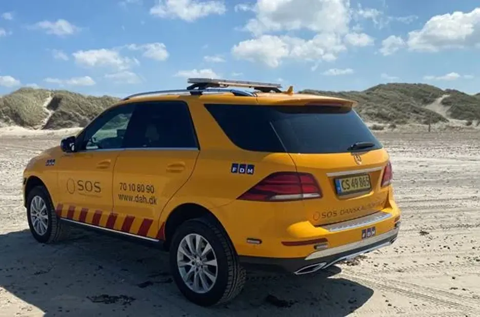 Autoredder bil på strand. Bilen er en Mercedes. 
