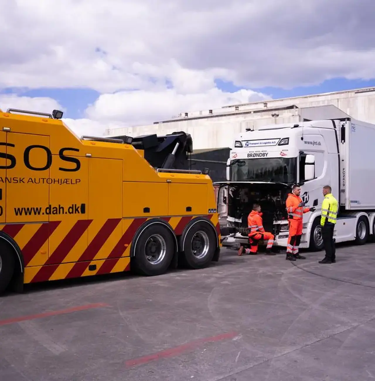 Stor autoredder bil hjælper en strandet lastbil med sættevogn