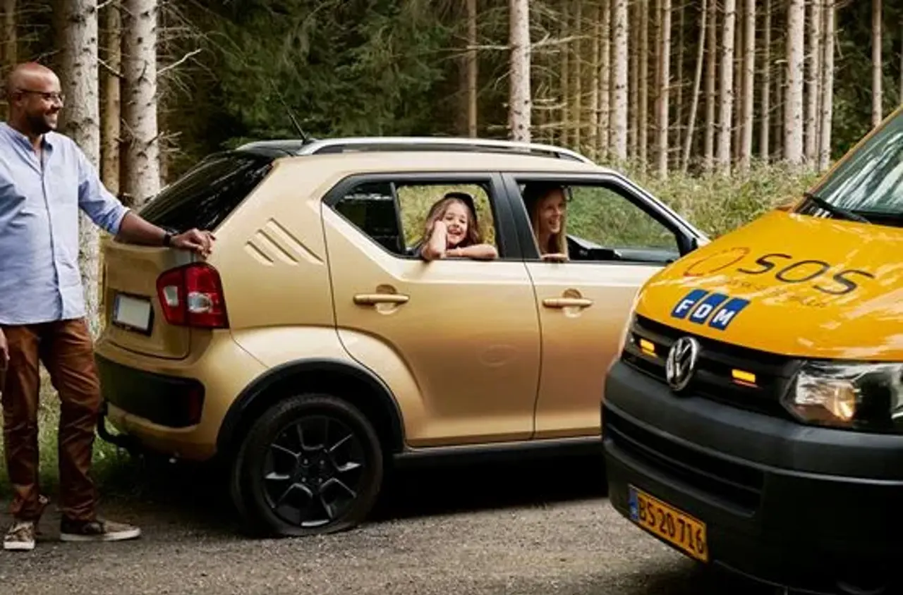 Gul bil hvor ejer står bag bilen. I bilen ses dame og datter. Til højre ses forenden af Autoredder bil