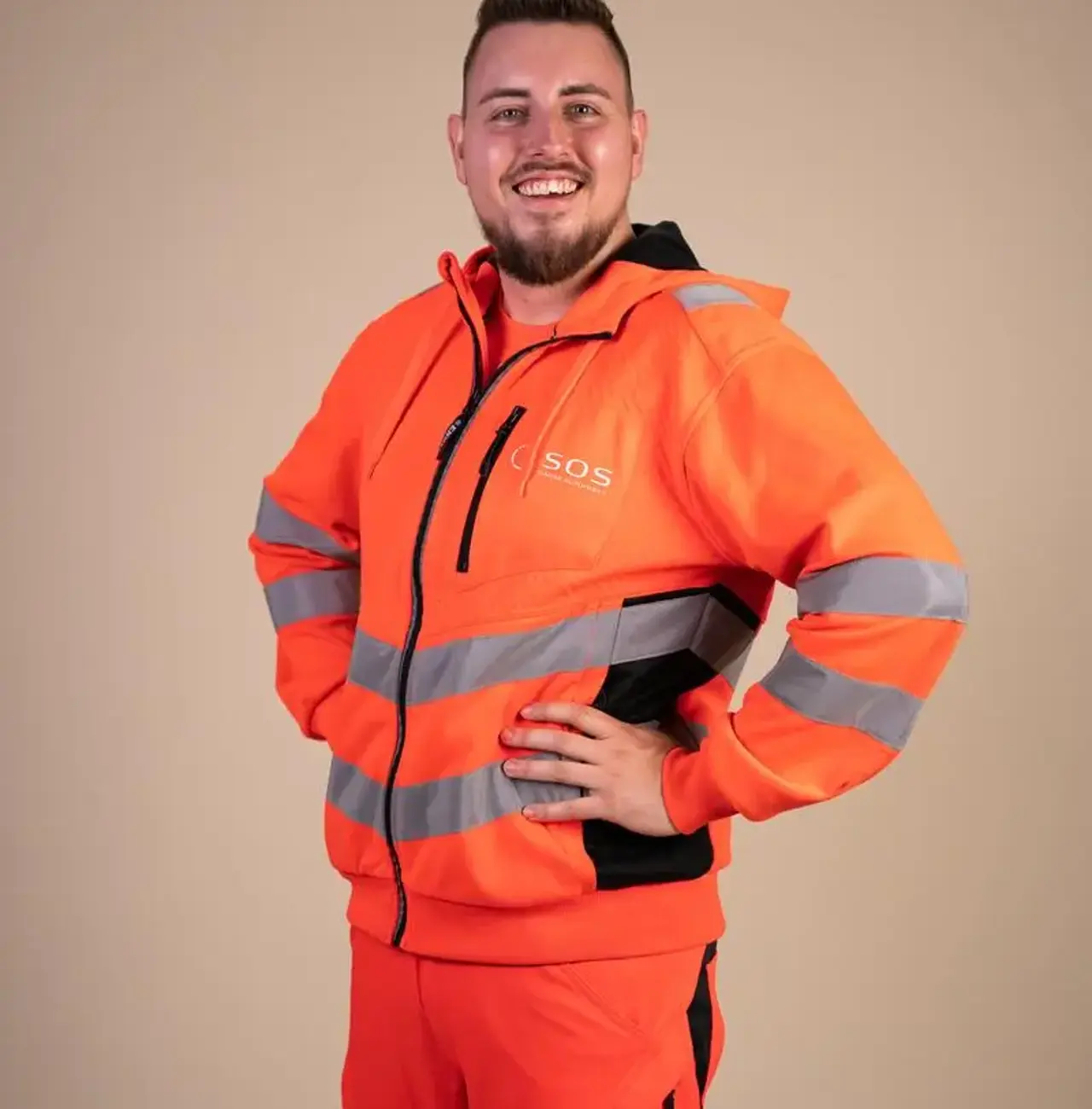 Autoredder der står med armene i siden og smiler