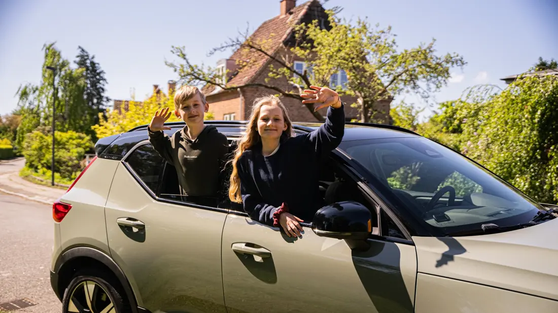 Børn vinker ud af vinduet