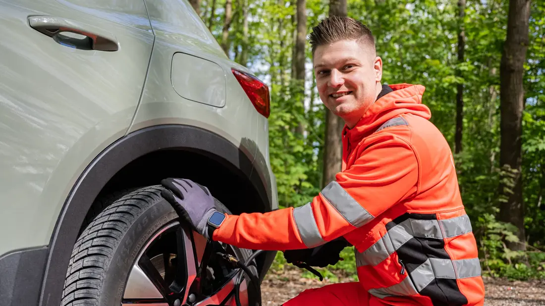 Autoredder sidder ved bagdæk