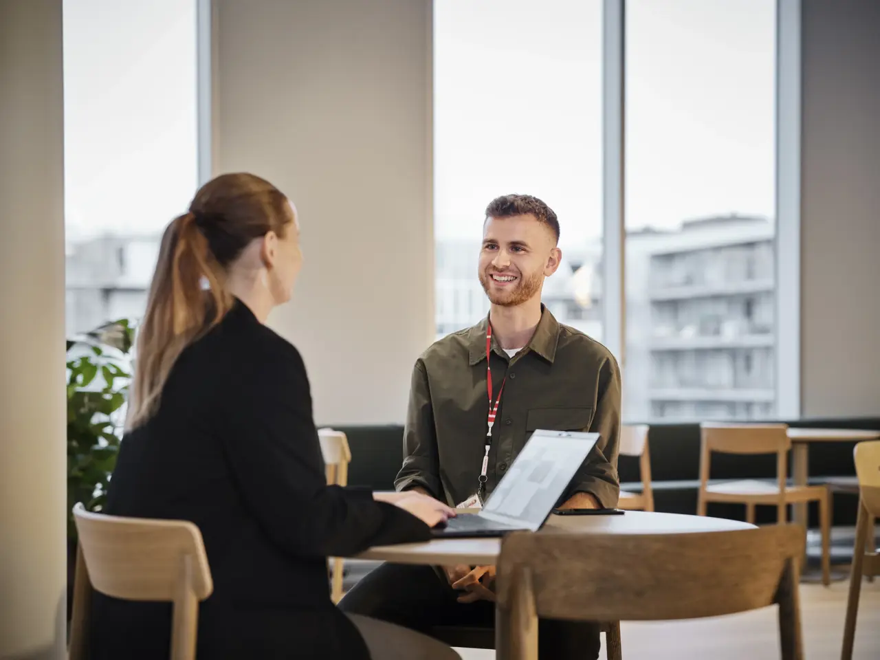 two people sitting at a table with a laptop