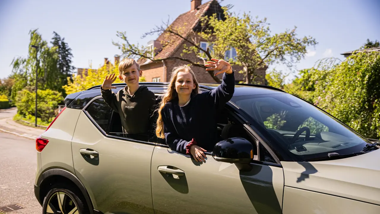 Børn vinker ud af vinduet