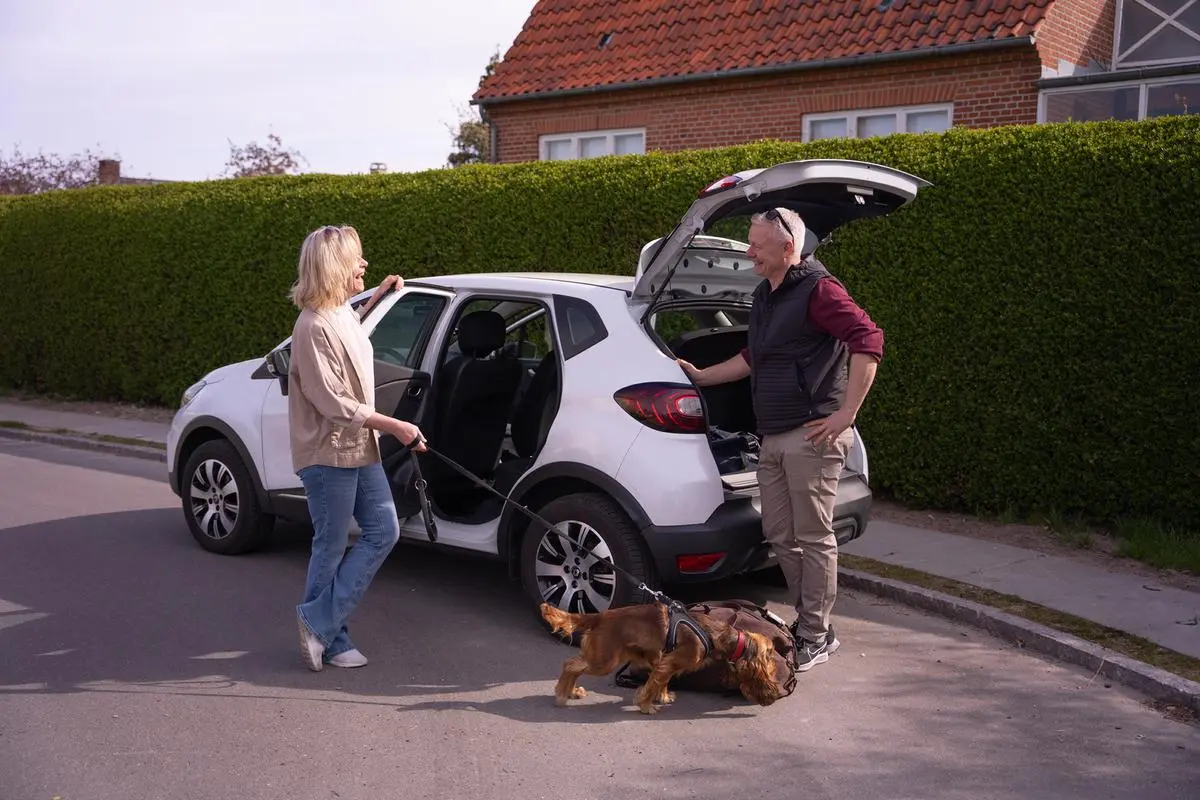 To personer er på vej på ferie med deres hund