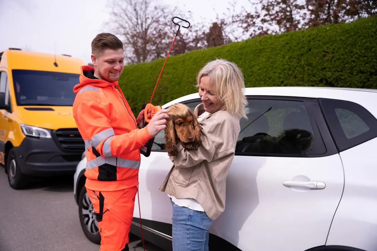 Autoredder står med hund