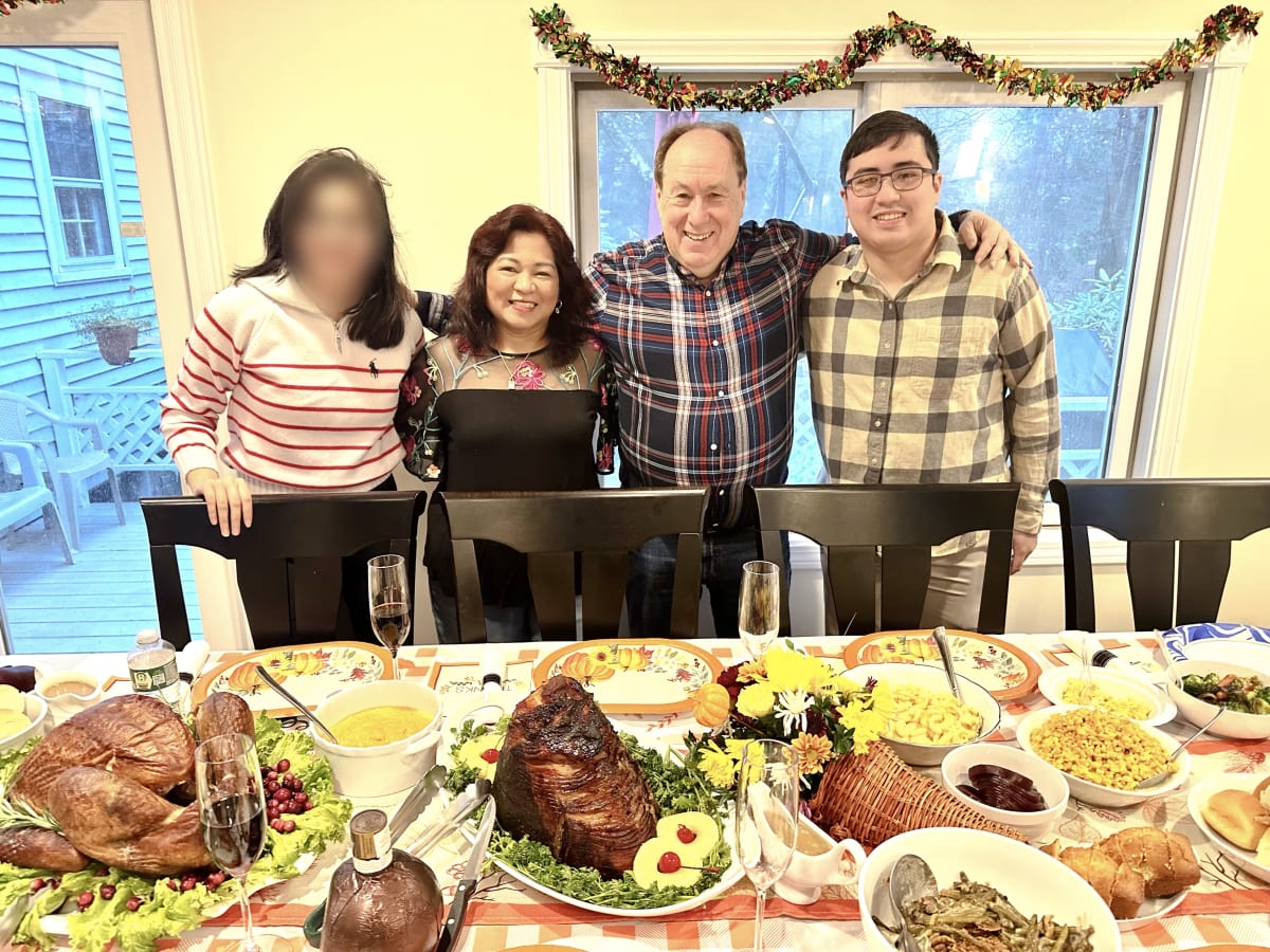 The Kutzko family at their holiday table, with their daughter's face blurred for privacy.