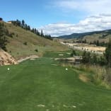 A view of the Black Mountain Golf Club in Kelowna showing a lush fairway with bunkers and a scenic mountainous backdrop.