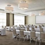 a conference room set up for a meeting with a projector screen and a projector screen on the wall