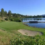a view of a golf course with a lake in the background and a golf club in the foreground at Shannon Lake Golf Course, West Kelowna