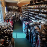 A well-organized indoor golf equipment storage room filled with numerous golf bags and clubs, located at The Golf Centre Practice Facility in Kelowna.