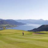 a person standing on a golf course overlooking a lake and a golf course with a person standing on the green at The Rise Golf Course in Vernon.