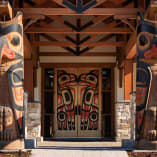 Entrance of Two Eagles Golf Course in West Kelowna featuring intricate eagle carvings and a door with indigenous art design.