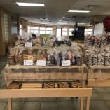 a table filled with lots of bags of donuts and other items in a room with tile flooring