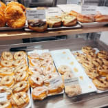 a display case filled with lots of different types of doughnuts on top of trays next to each other