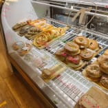 a display case filled with lots of different types of donuts and pastries in a deli or bakery