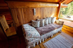 A floral-patterned daybed with several pillows in a cozy, wooden room in Kelowna.