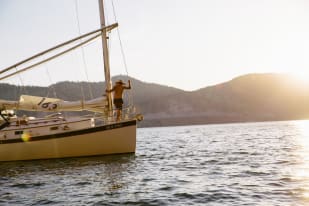 A person sailing on Okanagan Lake in the Thompson-Okanagan region at sunset.