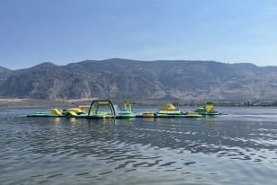 Colorful inflatable water park on a lake with mountains in the background in Osoyoos.