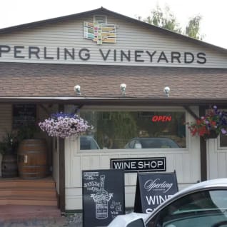 a wine shop with a car parked in front of it and a sign on the front of the building