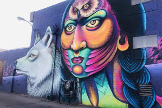 a mural on the side of a building with a wolf and a