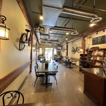 a restaurant with tables, chairs, and a long wall with a clock on