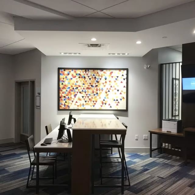 a room with a large painting on the wall and a long table with chairs in the middle of the room at Holiday Inn Express and Suites Kelowna - East in Kelowna.