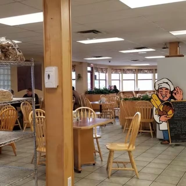 A store filled with lots of wooden furniture and shelves filled with baskets of bread and other items on shelves.