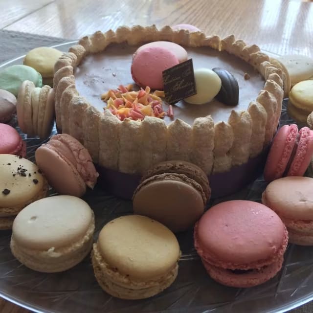 a plate with a variety of desserts on it on a wooden table next to a cup of coffee