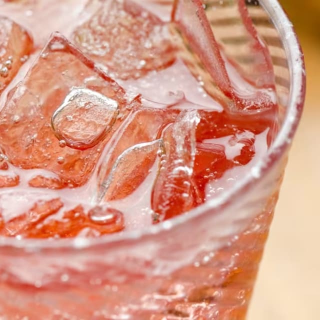 a close up of a glass of ice water with a straw in it and ice cubes on the rim at Marmalade Cat Cafe in Kelowna