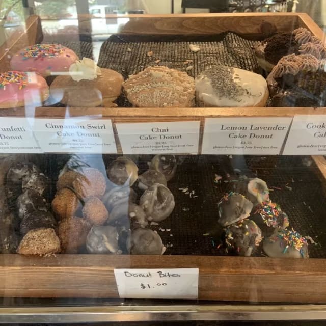 a display case filled with lots of different types of doughnuts in a store front window of a doughnut shop