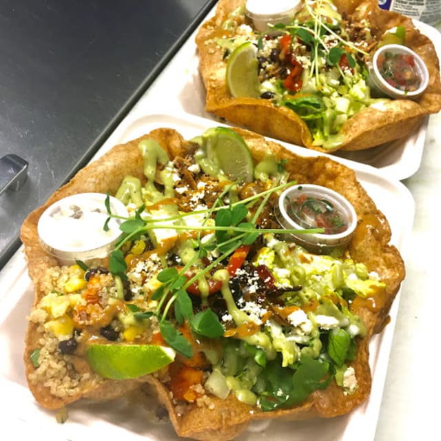 Two bowls of colorful salad with fresh vegetables, lime, and dressing, served in crispy edible bowls at The Roxy Cafe in Vernon.
