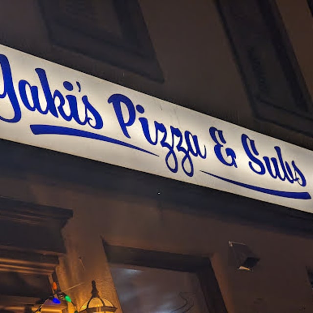 Signboard for Yaki's Pizza & Subs in Summerland, BC, illuminated at night.