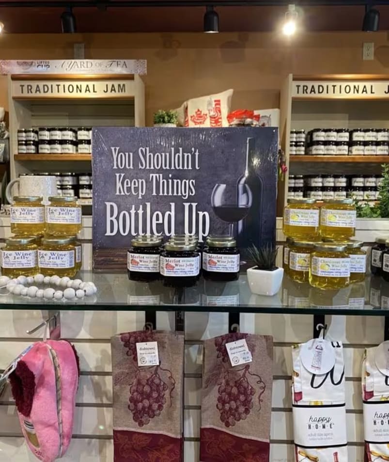 A display of various jams and jellies with a sign saying You Shouldn't Keep Things Bottled Up at The Jammery in Lake Country.