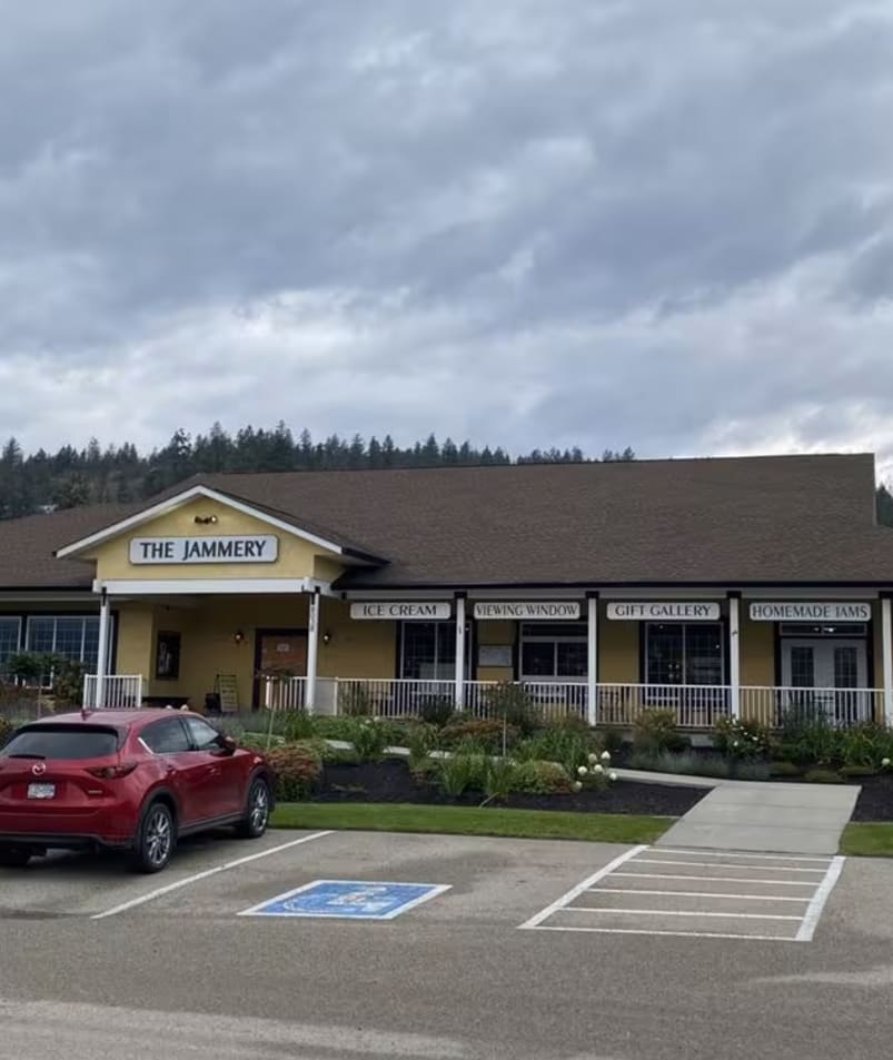The Jammery, a quaint building in Lake Country with signs for ice cream, a viewing window, a gift gallery, homemade jams, and loose leaf teas, with parking in front.